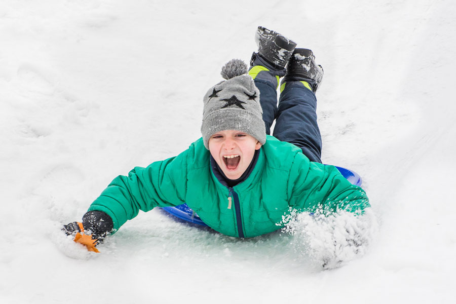 boy riding snow saucer