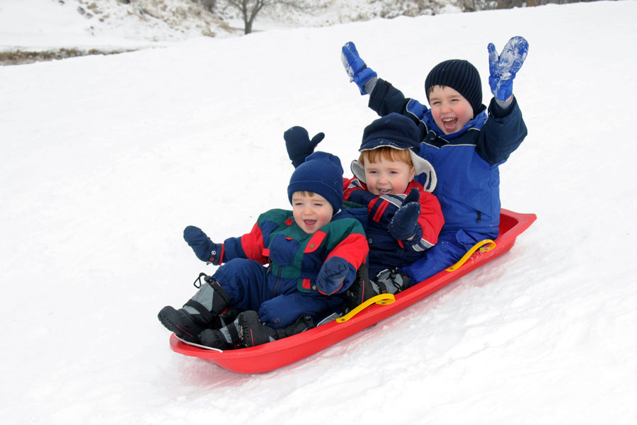 three kids sledding