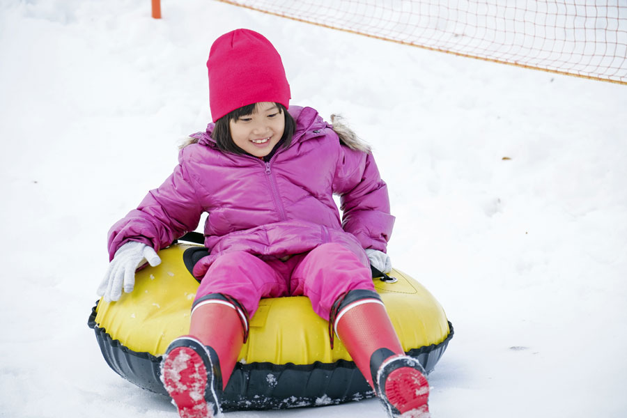 girl riding snow tube