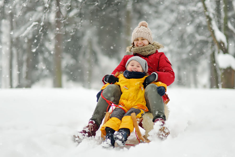 two people on snow sled